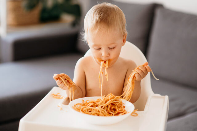 A child having sensory play with Pasta